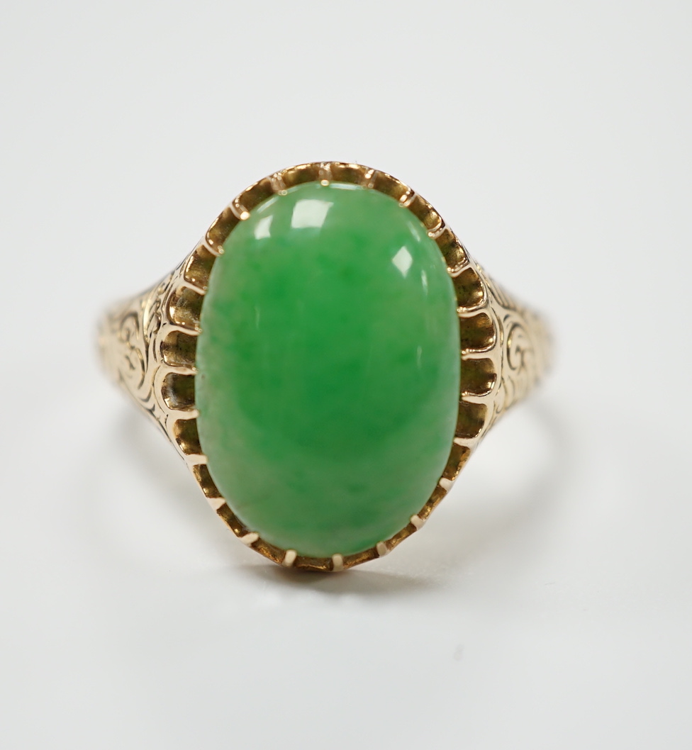 A yellow metal (stamped 18) and single stone cabochon jade set ring, size Q, gross weight 5.7 grams.